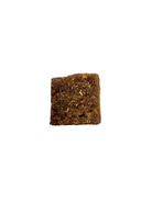 A single square brown textured food piece, resembling a granola or cereal clump, isolated on a solid white background.
